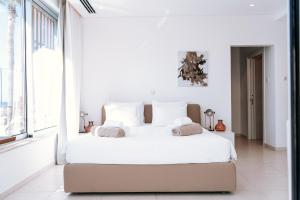 a white bedroom with a large bed and a window at Vivo Mare Beachfornt Villas - Azure in Ayia Napa