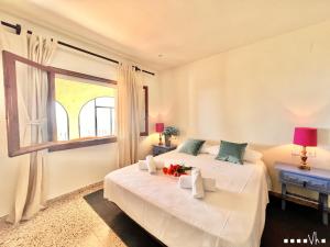 ベニッサにあるVH CostaBlanca - AGUILAの白いベッドルーム(ベッド2台、窓付)