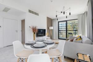 a white living room with a table and chairs at Shellter Apartments 117 K - by Jantar Apartamenty in Rogowo