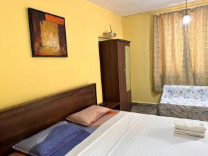 una camera d'albergo con letto e sedia di James Guesthouse a Bogmalo