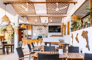 um restaurante com mesas e cadeiras de madeira em Dhiffushi Inn em Dhiffushi