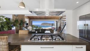 eine Küche mit einem Kochfeld in der Mitte eines Zimmers in der Unterkunft Renovated Beach House With Stunning Views and Short Walk To Beach in Copacabana