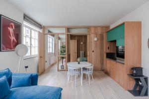een woonkamer met een blauwe bank en een tafel bij Casa Peppino - Soho - by Frankie Says in Londen