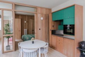 een keuken met een witte tafel en groene kasten bij Casa Peppino - Soho - by Frankie Says in Londen