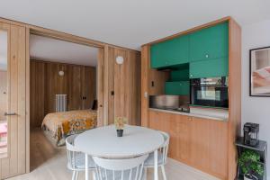 een keuken met groene kasten en een witte tafel in een kamer bij Casa Emilio - Soho - by Frankie Says in Londen