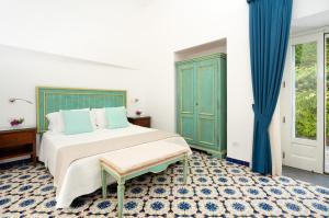 ein Schlafzimmer mit einem großen Bett und blauen Vorhängen in der Unterkunft Villa Bijoux - Exclusive pool and sea view in Amalfi