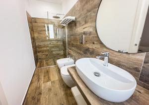 a bathroom with a sink and a mirror and a toilet at Piccolo Torino Rooms in Canicattì