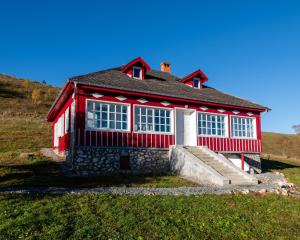 a red and white house on top of a hill at Casa de la Stanca Sirnea in Şirnea