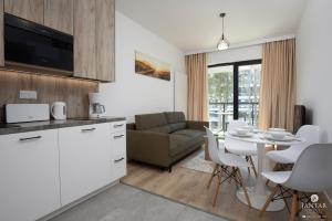 a kitchen and living room with a table and chairs at Shellter Apartments 117 M - by Jantar Apartamenty in Rogowo