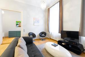 uma sala de estar com um sofá e uma TV em Luxury Apartment with Spacious Livingroom at Opera House em Budapeste