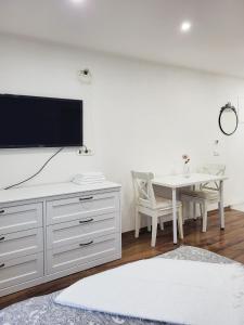 a living room with a table and a tv on a wall at Stara Pošta Apartment 5 in Grosuplje
