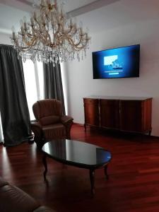 a living room with a chandelier and a coffee table at Apartma Bistrica in Slovenska Bistrica