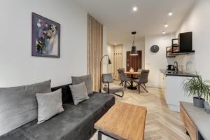 een woonkamer met een bank en een tafel bij Aura III Apartments & Free Parking by Downtown Apartments in Gdańsk