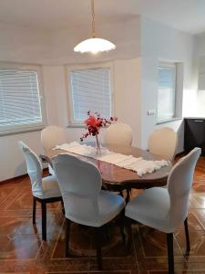 a dining room table with chairs and a vase of flowers on it at Apartma Bistrica in Slovenska Bistrica