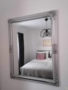 einen Spiegel, der ein Bett im Schlafzimmer reflektiert in der Unterkunft Apartma Bistrica in Slovenska Bistrica