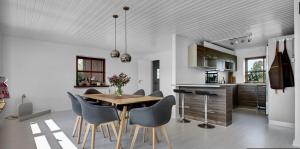cocina y comedor con mesa de madera y sillas en 4 bedroom 200m2 luxury house with garden in Horsens, en Horsens