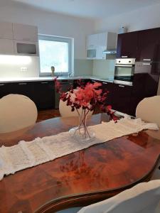 Apartma Bistrica في سلوفينيسكا بيستريسا: مطبخ مع طاولة عليها إناء من الزهور