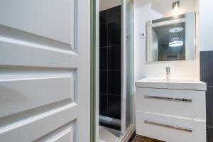 een badkamer met een wastafel en een spiegel bij NEW - Designer Flat for 4 pp in Parijs
