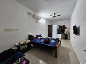 a bedroom with a bed and a person standing in a room at The Urban Escape in Udupi