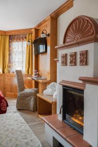 een woonkamer met een open haard en een stoel bij Hotel Gianna in Madonna di Campiglio