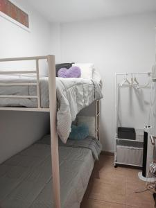 um quarto com um beliche com paredes brancas em Calesapart Tranquilidad con vistas al mar em Candelaria