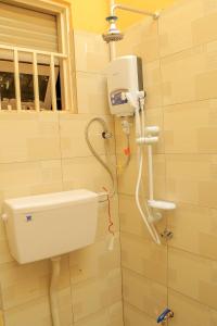 a bathroom with a water tank and a toilet at Exotic Inn and Apartments in Kampala