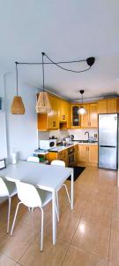 a kitchen with a white table and a white refrigerator at Calesapart Tranquilidad con vistas al mar in Candelaria