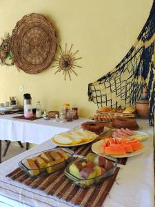 una mesa con platos de comida encima en Casa Aroeira Pousada, en Ilhéus