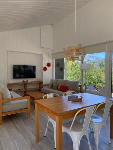 una sala de estar con una mesa y un sofá en Moderna casa en el bosque, en San Martín de los Andes