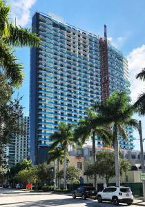 un grande edificio con palme di fronte di Quiet & Centrally located House - PRIVATE PARKING, LAUNDRY AND STORAGE FOR LUGGAGE a Miami