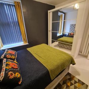 a bedroom with a bed and a mirror at The Holiday 20 flat! outside LEZ in Aberdeen