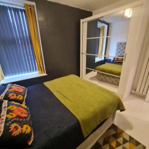 a bedroom with a bed and a mirror at The Holiday 20 flat! outside LEZ in Aberdeen