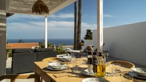 a wooden table with plates and glasses on a patio at Casa Peponi - By Almarina Villas in Jávea