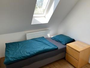 una camera da letto con un letto con lenzuola blu e una finestra di Jelen a HoÅ¡Å¥ka