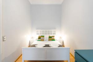 um quarto branco com uma cama branca e 2 almofadas em Luxury Apartment with Spacious Livingroom at Opera House em Budapeste