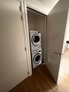 een wasmachine en droger in een kleine kamer bij Luxe recreatiewoning midden in bosrijke omgeving in Waalre