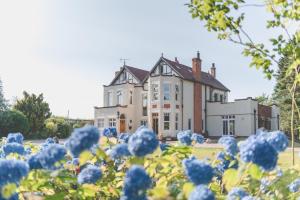 una casa vieja con flores azules delante de ella en Mere Brook House en Wirral