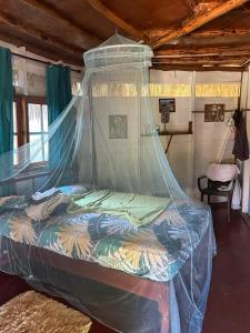 a bedroom with a bed with a mosquito net at Little Bay Bungalow in Little Bay