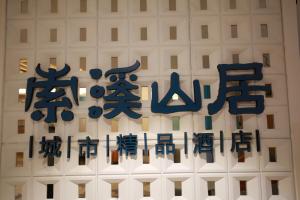 a sign with chinese writing on a white building at Zhangjiajie lollipop Hotel in Zhangjiajie