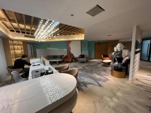 a lobby with people sitting in chairs and a table at Zhangjiajie lollipop Hotel in Zhangjiajie