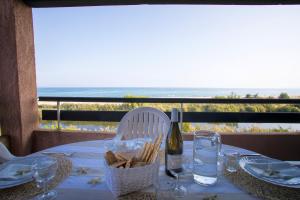 a table with a bottle of wine and a basket of bread at Residence de Tourisme Marina Corsa in Ghisonaccia