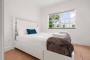 a white bedroom with a large bed with a window at Renovated 3 Rooms House ! in Miami