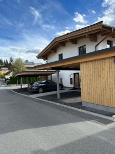 ein Gebäude mit einem Auto auf einem Parkplatz in der Unterkunft Kaiserresidenz Ellmau in Ellmau