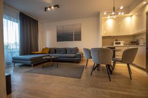 un soggiorno con divano, tavolo e sedie di Apartments Royal - Belgrade Waterfront a Belgrado