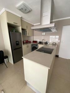 cocina con encimera blanca y nevera en Marina Bay Apartment, en Durban