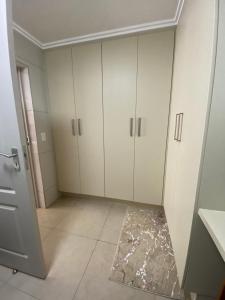 baño con armarios blancos y suelo de baldosa. en Marina Bay Apartment, en Durban