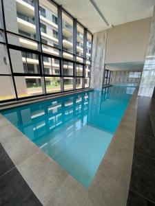 a large swimming pool in a building with windows at 1 Bedroom Marina Bay Apartment 7 in Durban