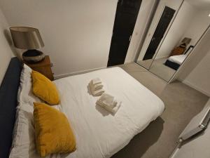 - une chambre avec un lit doté d'oreillers jaunes et d'un miroir dans l'établissement Superb 3 Bed Home Away from Home in Glasgow, just off M8 with free parking, à Steps