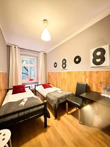 a hotel room with two beds and a desk at Explorer B&B Old Town Rooms & Apartment #don't be a tourist, be an Explorer! in Poznań