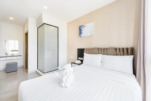 een slaapkamer met een groot wit bed en een grote spiegel bij Wyndham Royal Lee Phuket in Nai Yang Beach